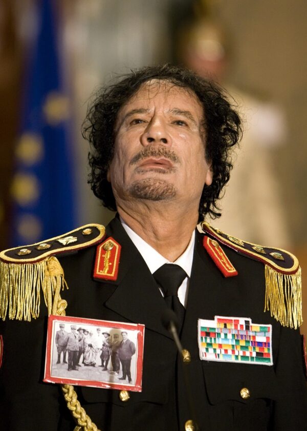 Libyan leader Muammar Gaddafi with a photo of Omar al-Mukhtar, 2009.