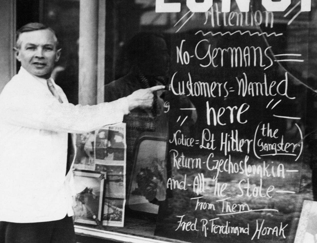 Владелец ресторана показывает надпись о том, что немцы не обслуживаются пока Гитлер не вернёт Чехословакию (город Сомервилл, штат Массачусетс, США; март 1939)