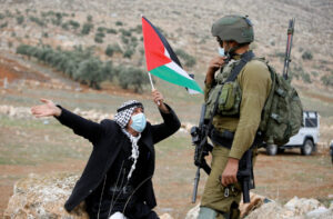 Палестинский демонстрант перед израильским солдатом, 2020 год